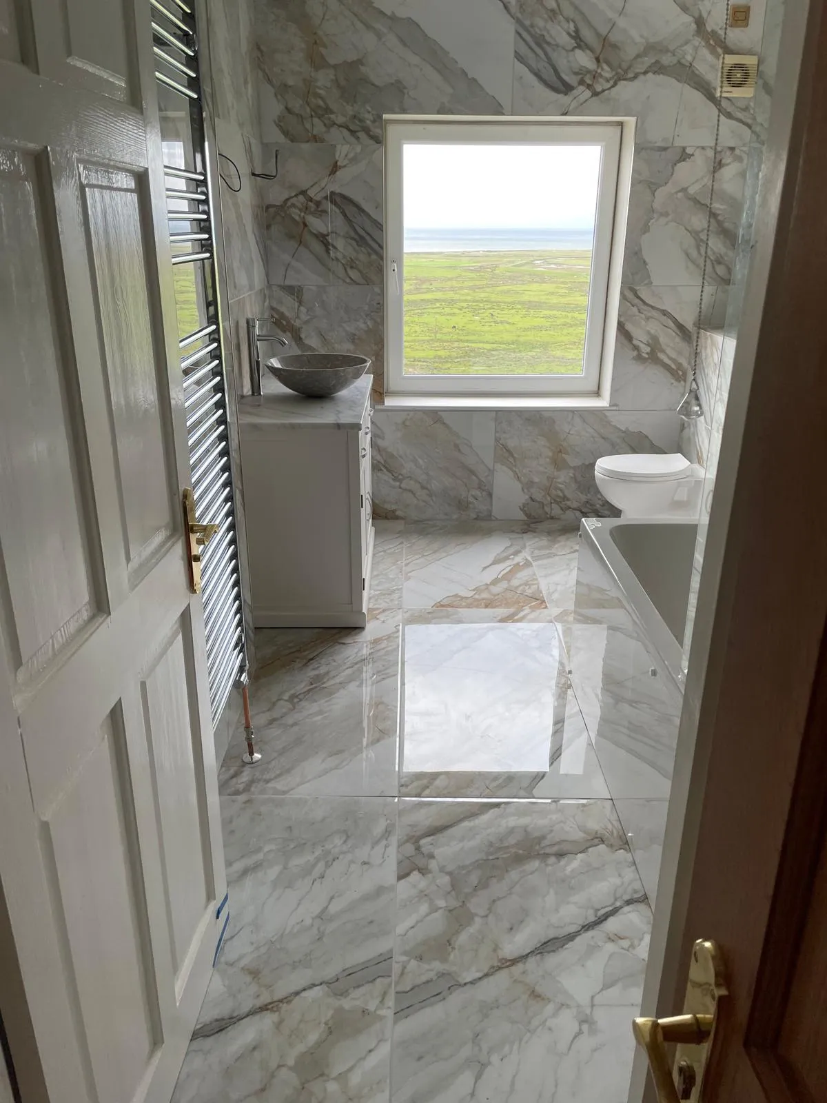 Marble bathroom with estuary view fitted near Aberdyfi by CR Plumbing