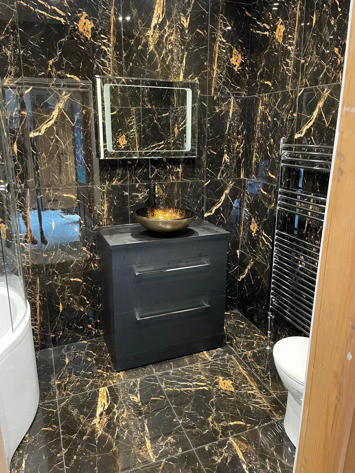 Black and gold marble bathroom with vessel basin fitted by CR Plumbing